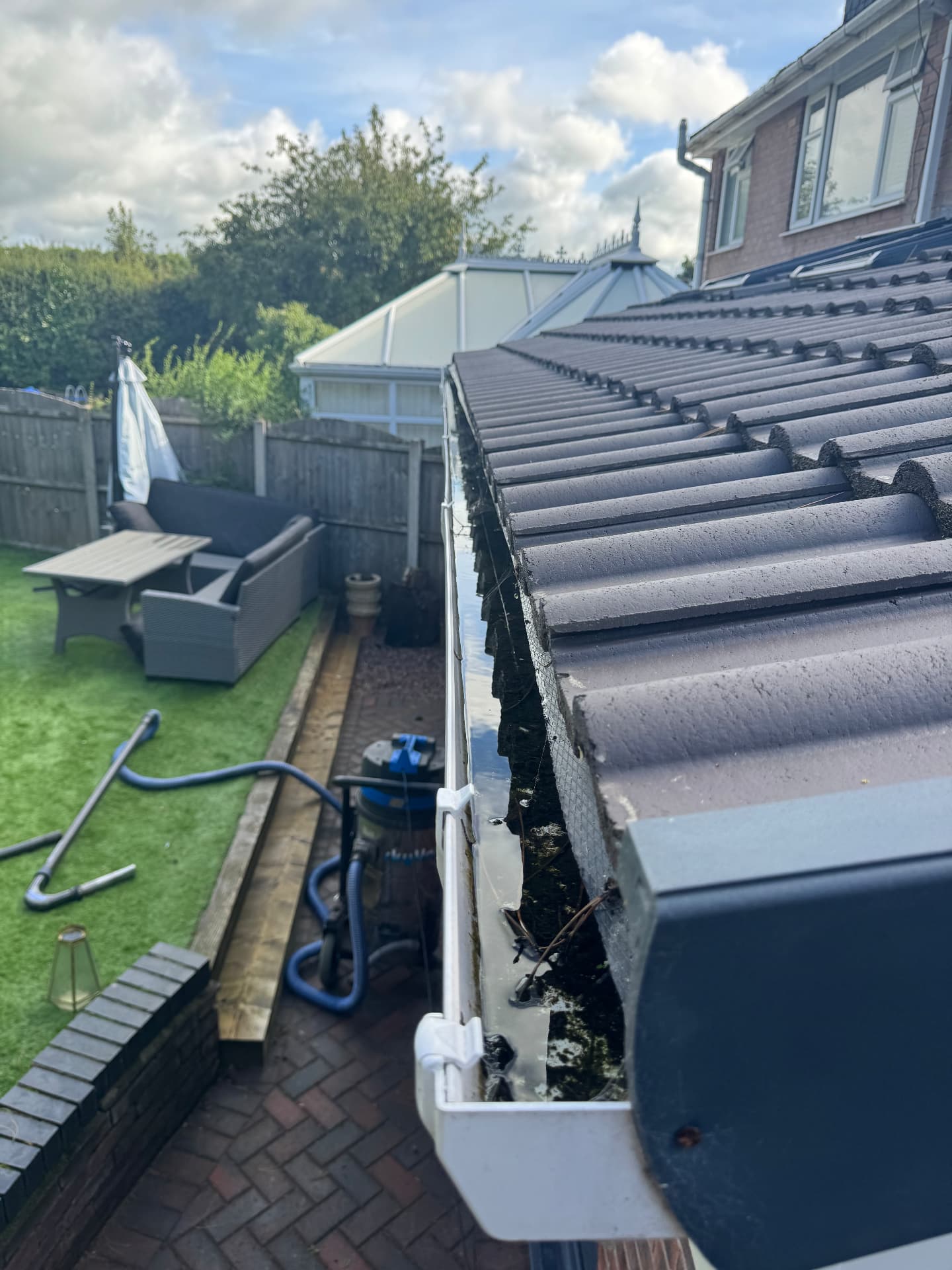 Gutter cleared out — leaves and moss removed — before cleaning