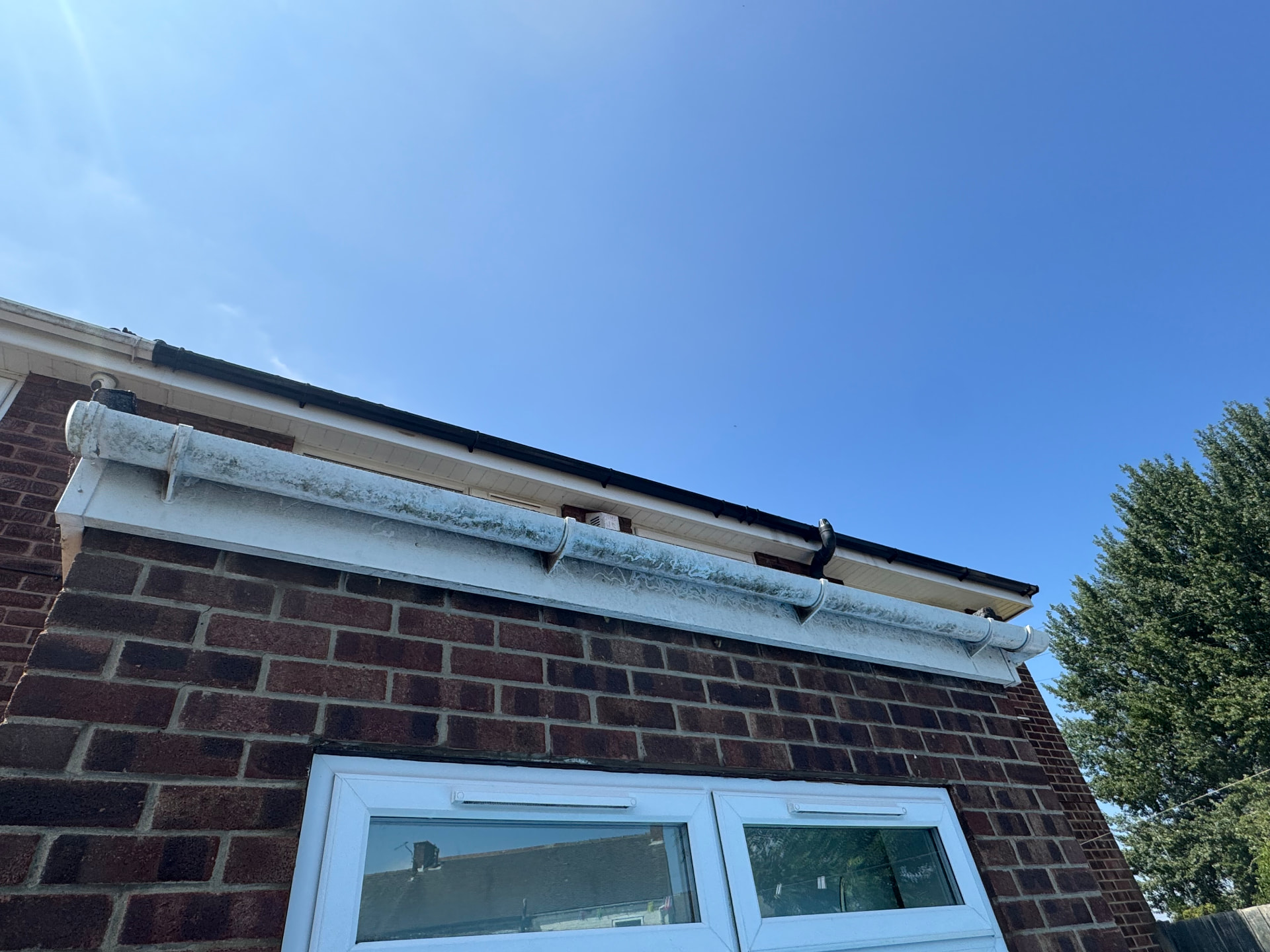 Moss and algae stripped from guttering — before cleaning