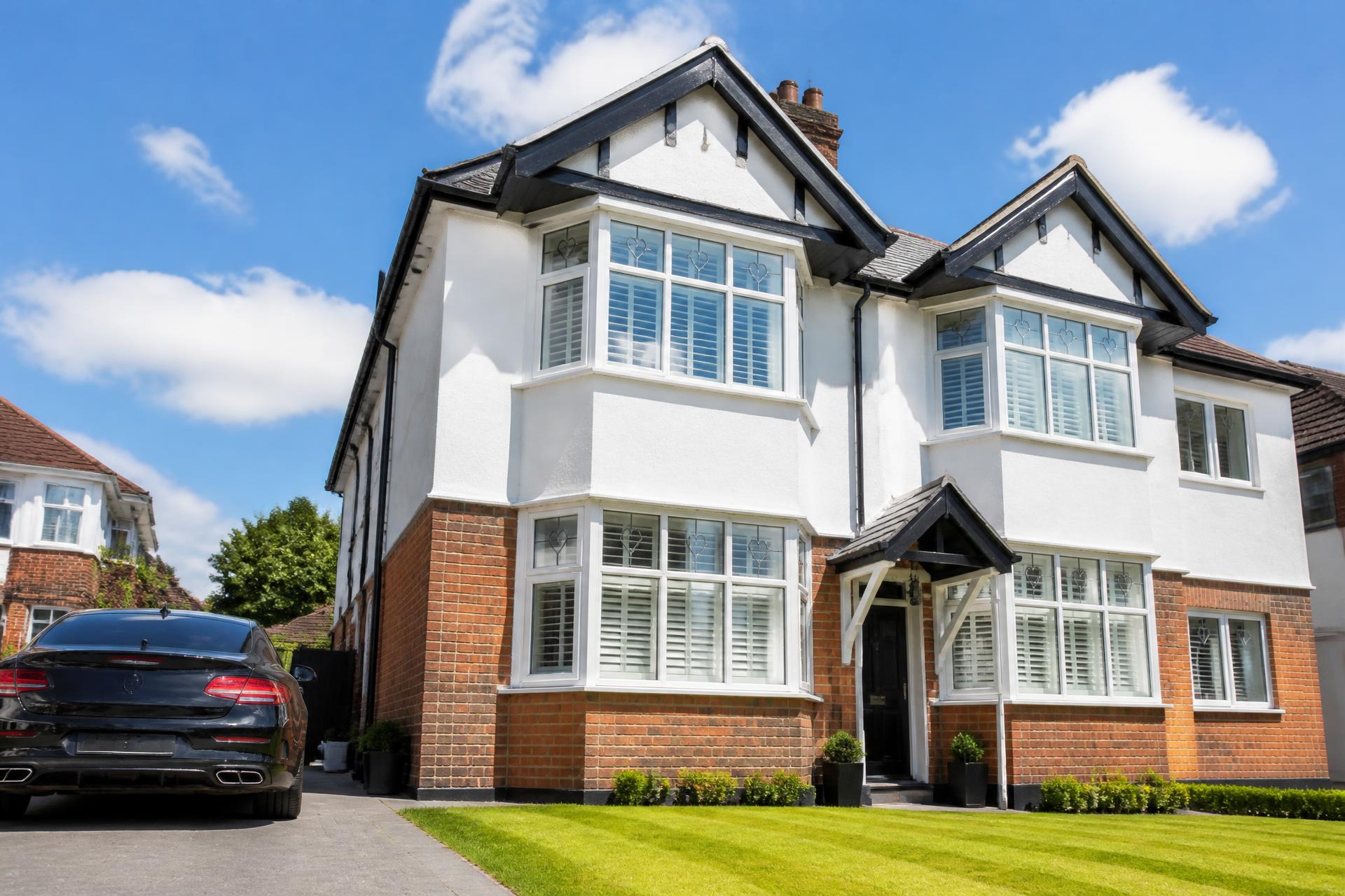 Window cleaner using a water-fed pole on a house in Newcastle-under-Lyme